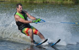 A man water-skiing while being towed by a boat.